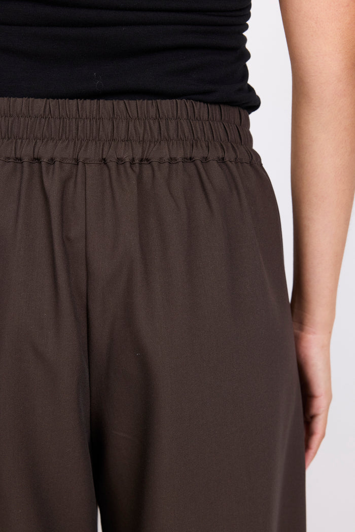 Brown pants worn by a person on a light gray background
