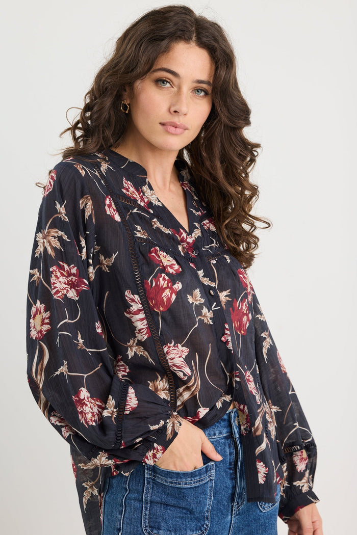 Woman wearing a floral blouse with a plain background