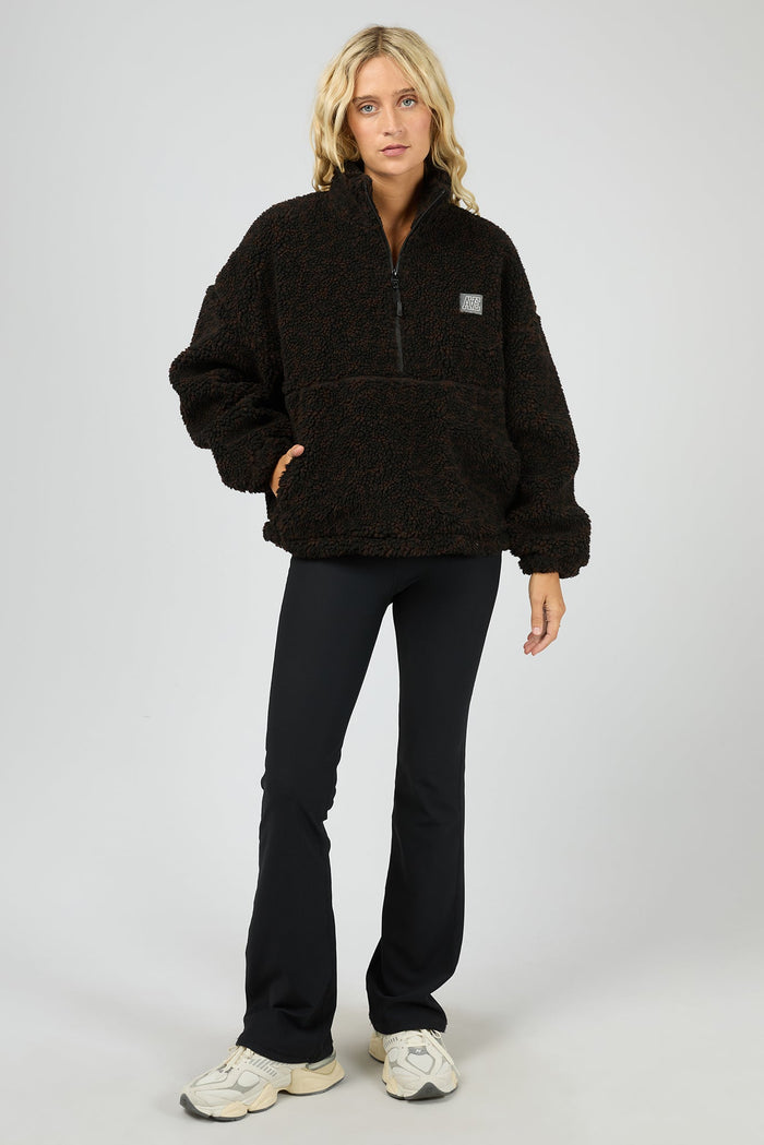 Person wearing a black fleece pullover with a white background