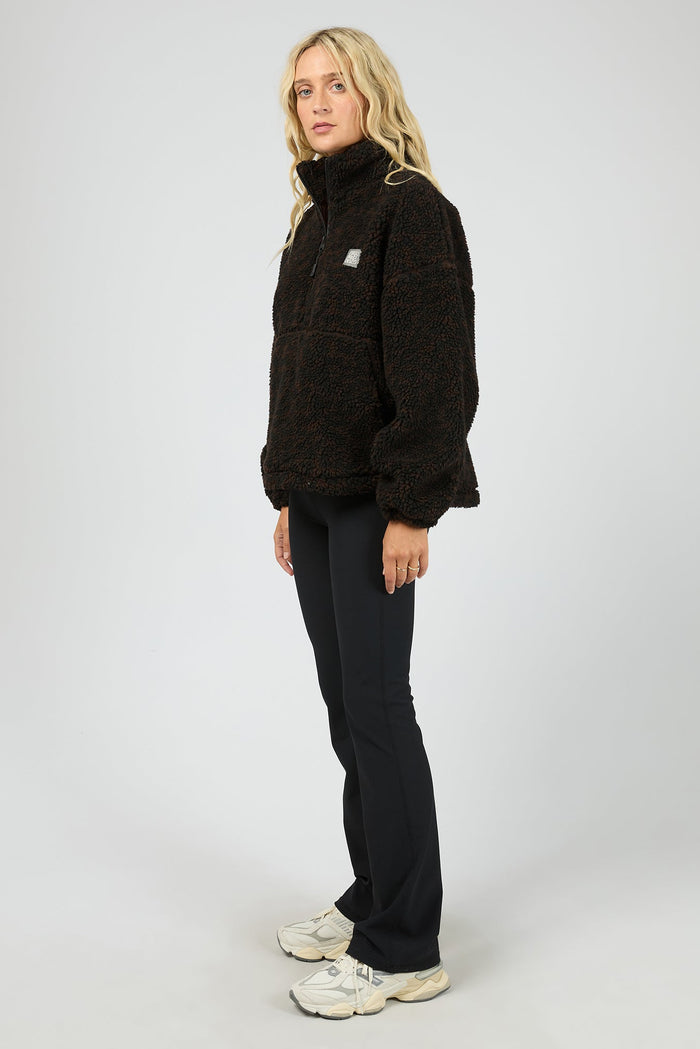 Person wearing a black pullover with a logo on a white background