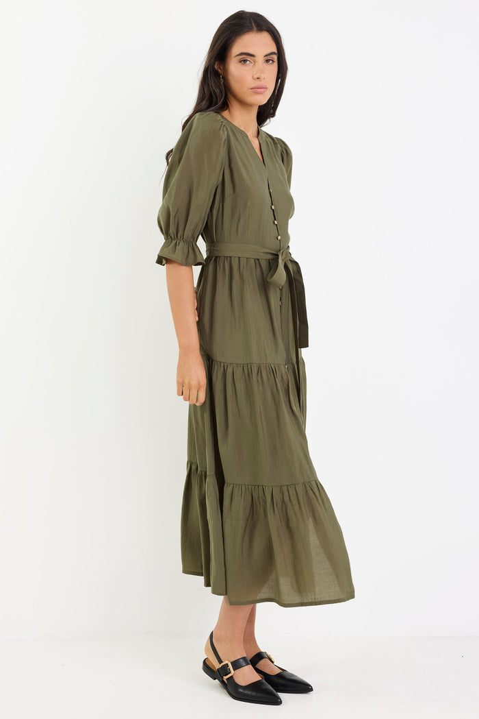Woman wearing an olive green dress on a white background