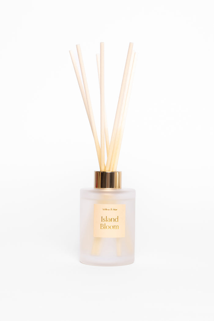 Diffuser with wooden sticks labeled 'Island Bloom' on a white background