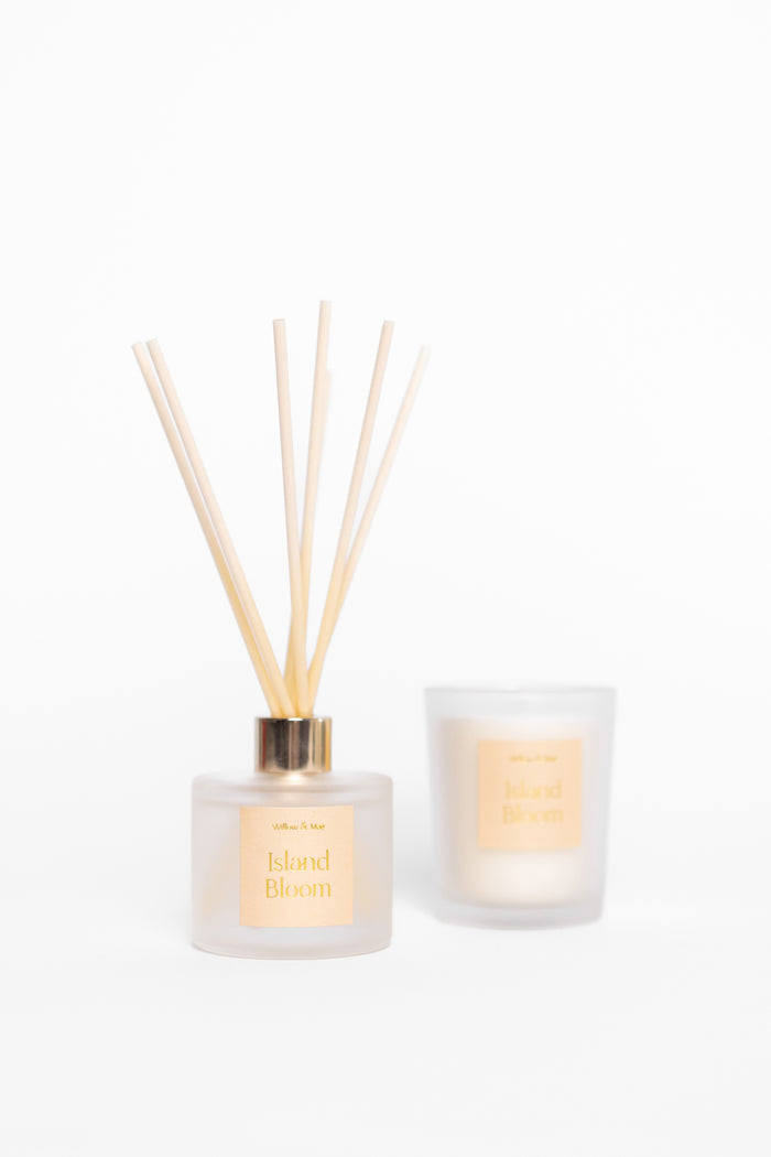 Diffuser with reeds and candle on a white background