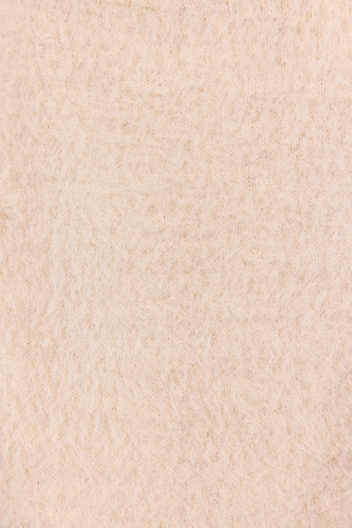 A close-up texture shot of a warm cream or off-white felted wool fabric, showing its soft, fibrous surface.
