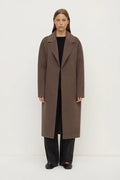 Person wearing a brown coat on a white background