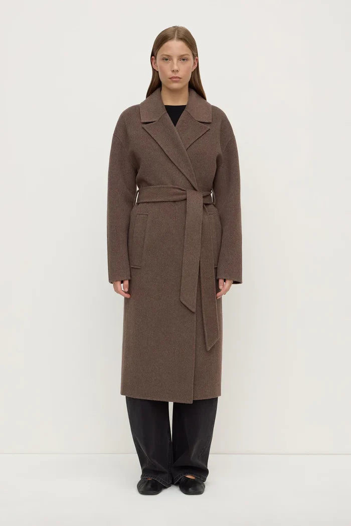 Woman wearing a brown coat on a white background