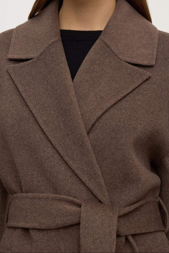 Brown coat worn by a person on a white background