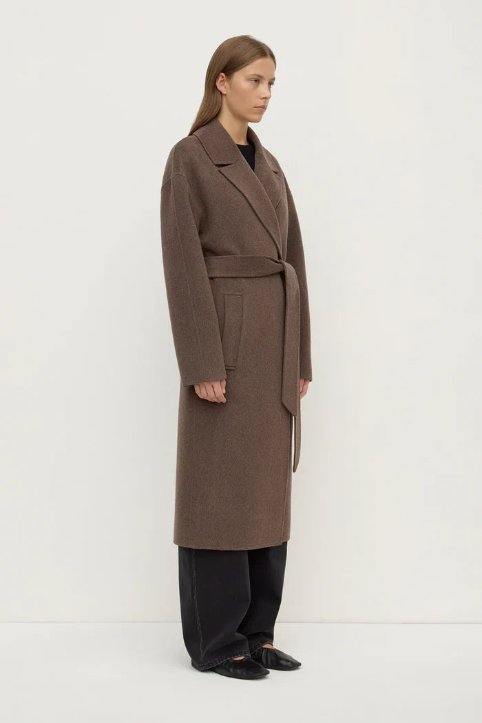 Woman wearing a brown coat on a white background