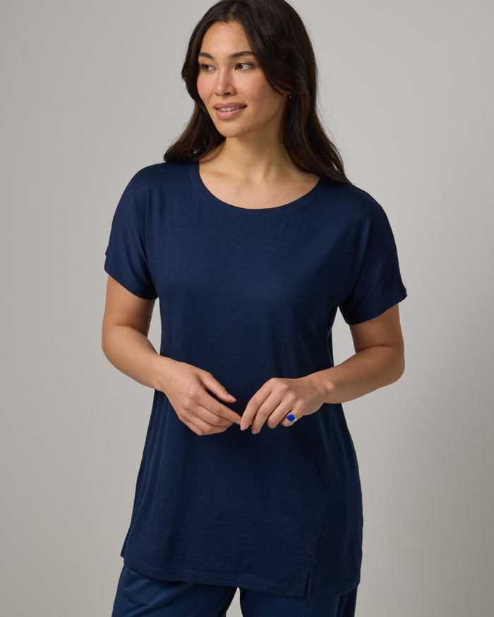 Model wearing Jade Tunic Tee in Marine Blue, a deep royal blue color. Jade Tunic Tee is a merino wool short sleeve, crew neck, relaxed fit tunic available in sizes XS-3X.