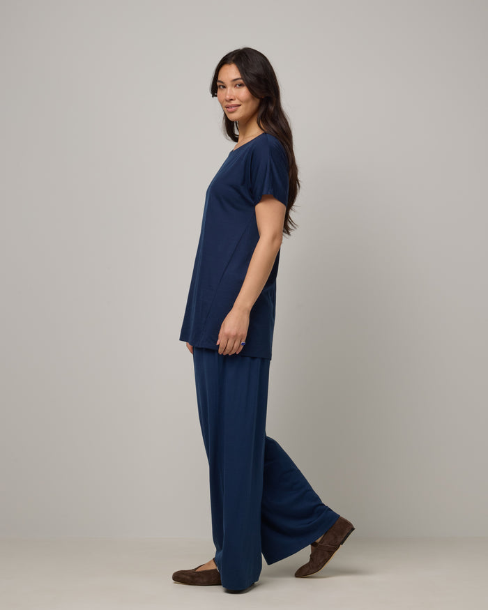 Model wearing Jade Tunic Tee in Marine Blue, a deep royal blue color. Jade Tunic Tee is a merino wool short sleeve, crew neck, relaxed fit tunic available in sizes XS-3X.