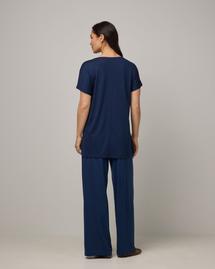 Model wearing Jade Tunic Tee in Marine Blue, a deep royal blue color. Jade Tunic Tee is a merino wool short sleeve, crew neck, relaxed fit tunic available in sizes XS-3X.