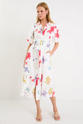 Model wearing a cream midi shirt dress with colourful poppy floral print, puff sleeves and a waist tie.