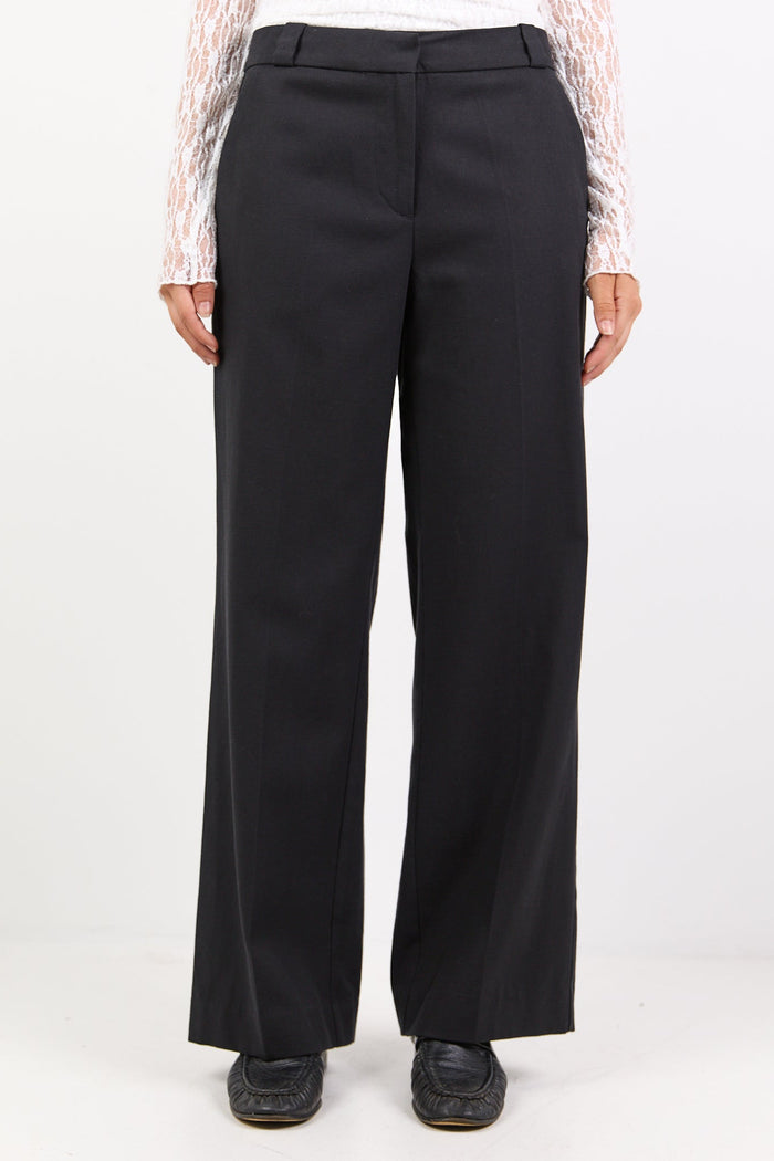 Black wide-leg pants worn by a person on a white background
