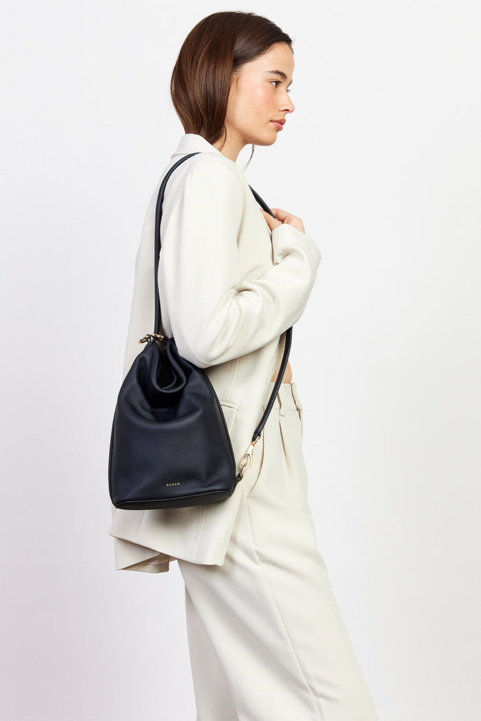 Woman carrying a black backpack against a white background
