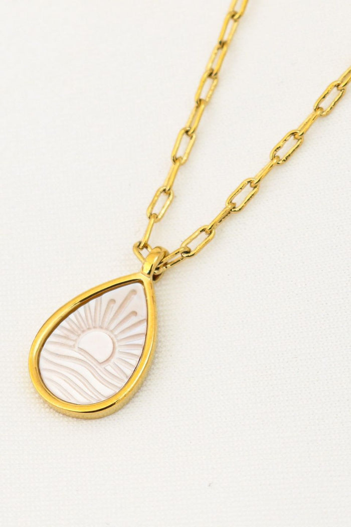 Gold necklace with a teardrop-shaped pendant on a white background