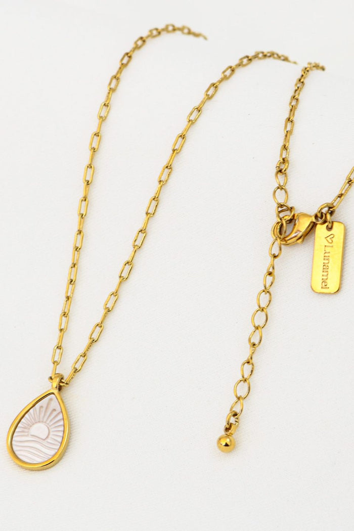 Gold necklace with a teardrop-shaped pendant on a white background