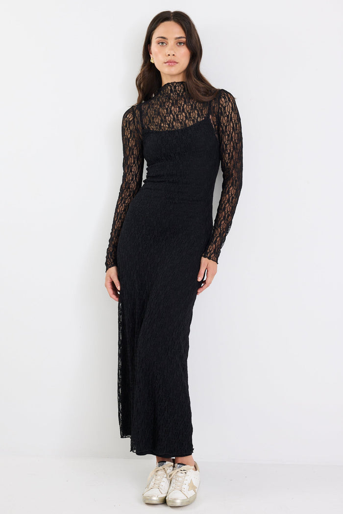 Woman wearing a black dress with lace sleeves on a white background