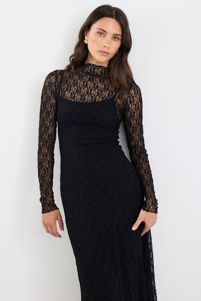 Woman wearing a black lace dress against a white background