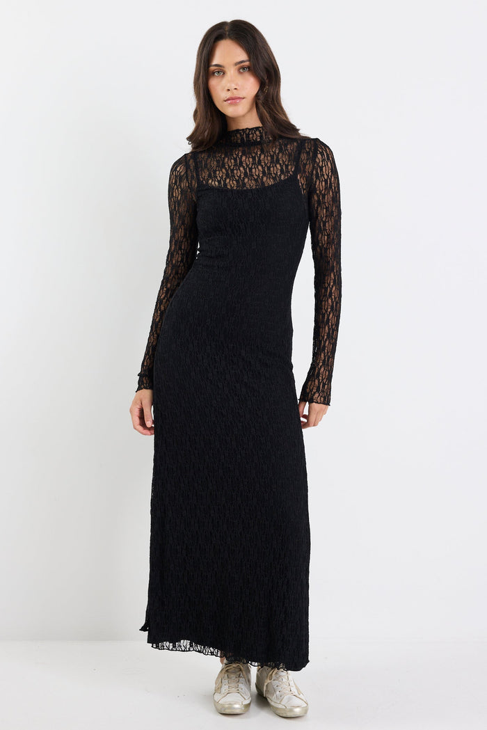 Woman wearing a black dress with lace sleeves on a white background