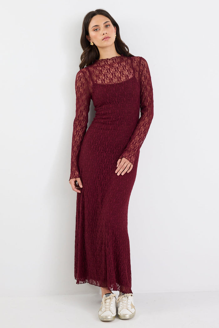 Woman wearing a burgundy lace dress on a white background