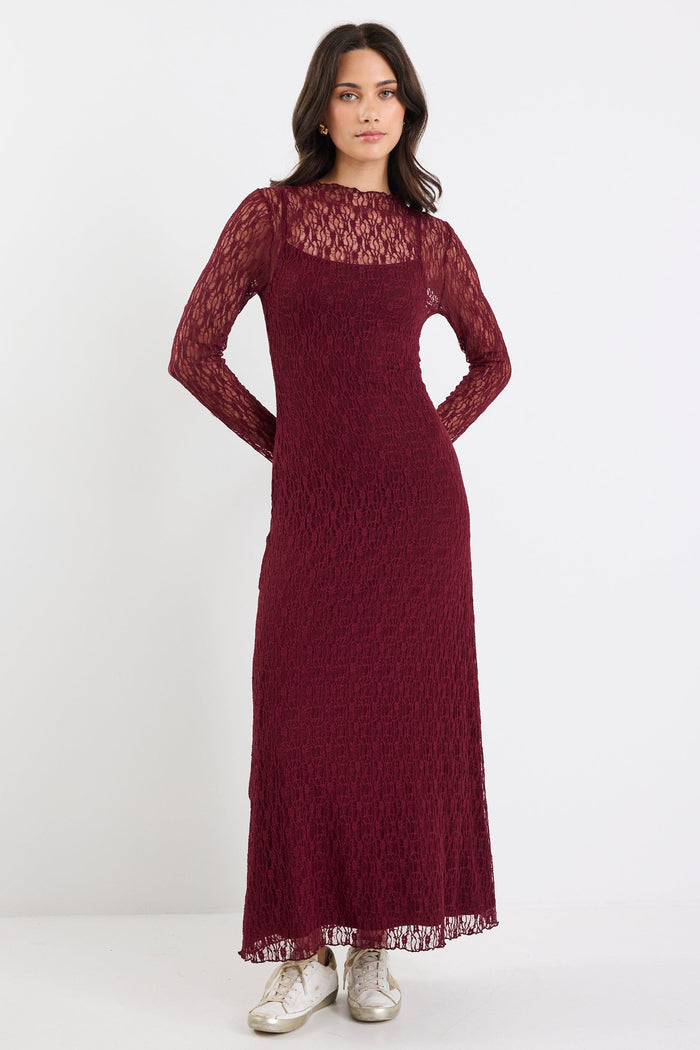 Woman wearing a burgundy lace dress on a white background