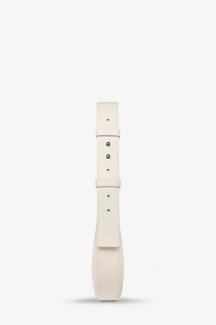 A cream-colored leather belt with silver-tone metal hardware, shown vertically against a plain white background.