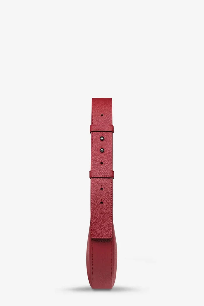 A single red textured leather watch strap shown vertically against a clean white background.