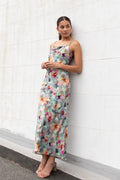 Model wears a blue floral maxi dress with a tie back and adjustable straps