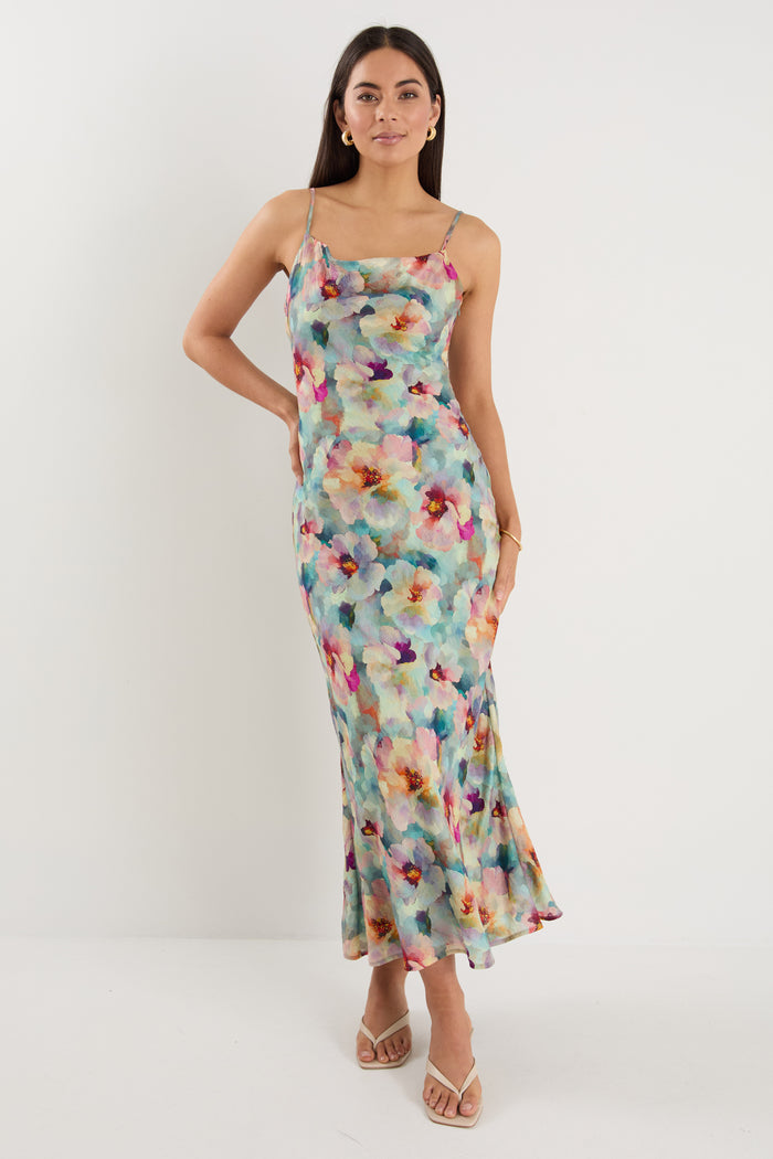 model wears a blue floral maxi dress with white heels