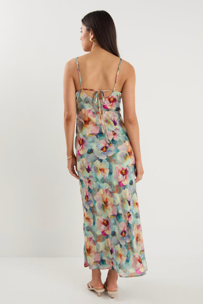model wears a blue floral maxi dress with white heels