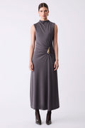 Woman wearing a sleeveless gray dress with a gold belt on a white background