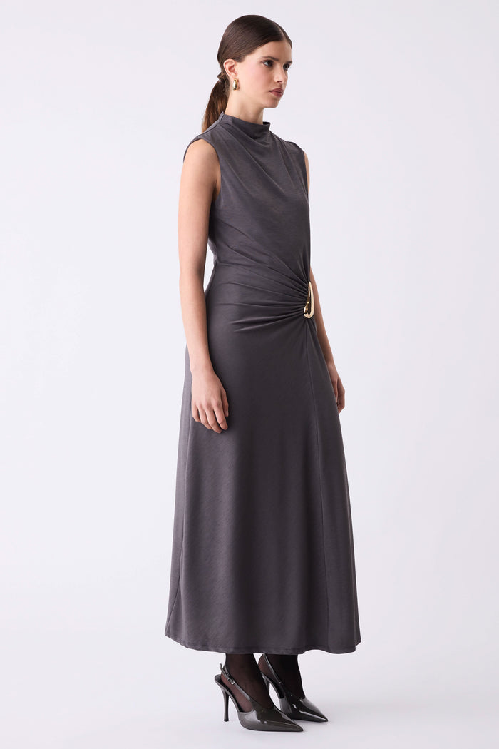 Woman wearing a sleeveless dark gray dress on a white background