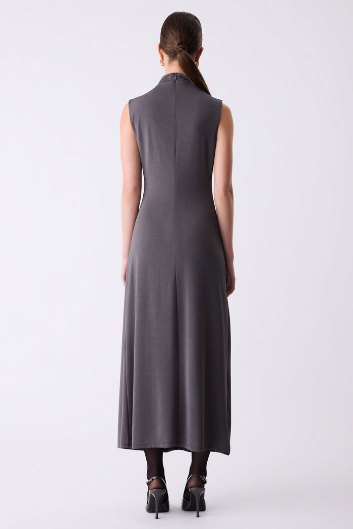 Woman wearing a long dark gray dress on a white background