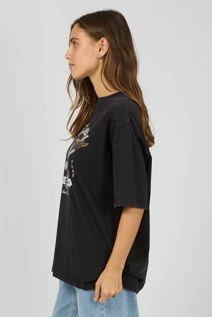 Person wearing a black oversized t-shirt and light blue jeans on a white background