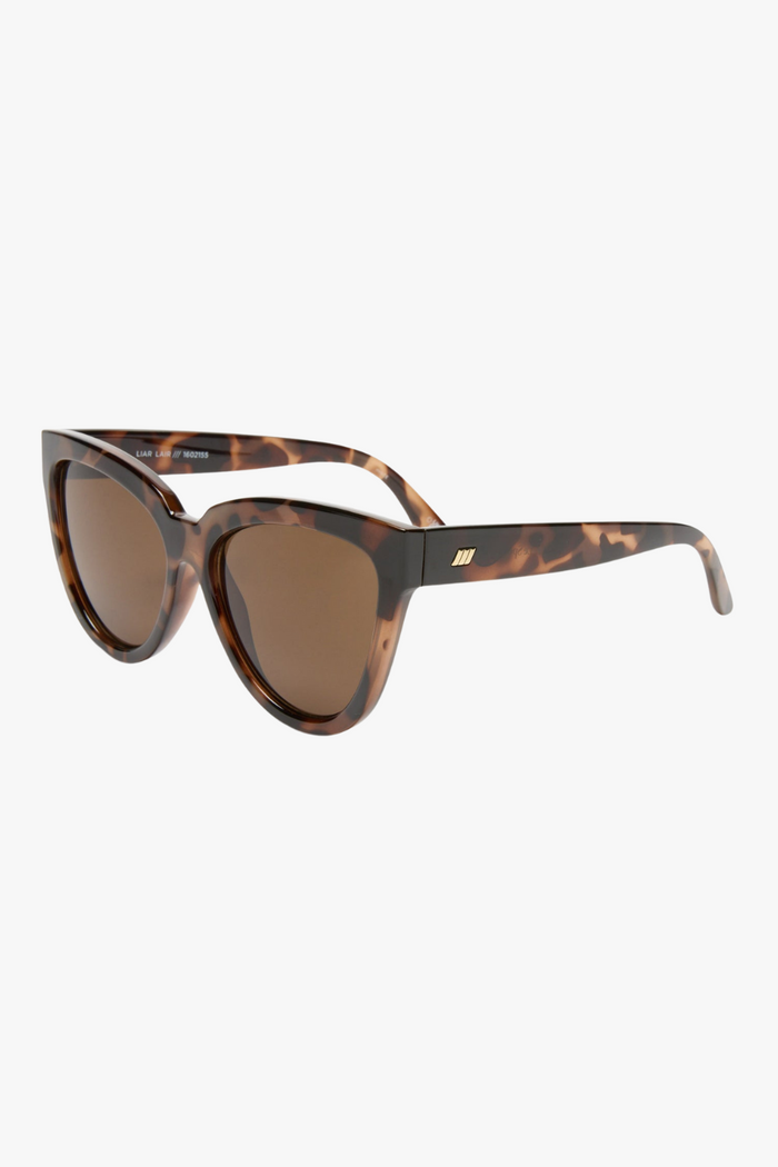 Front-facing view of oversized cat-eye sunglasses in a glossy tortoiseshell frame with warm brown lenses. The bold, sculpted silhouette adds a vintage-inspired edge with a modern twist.