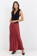 Woman wearing a black top and burgundy skirt on a white background