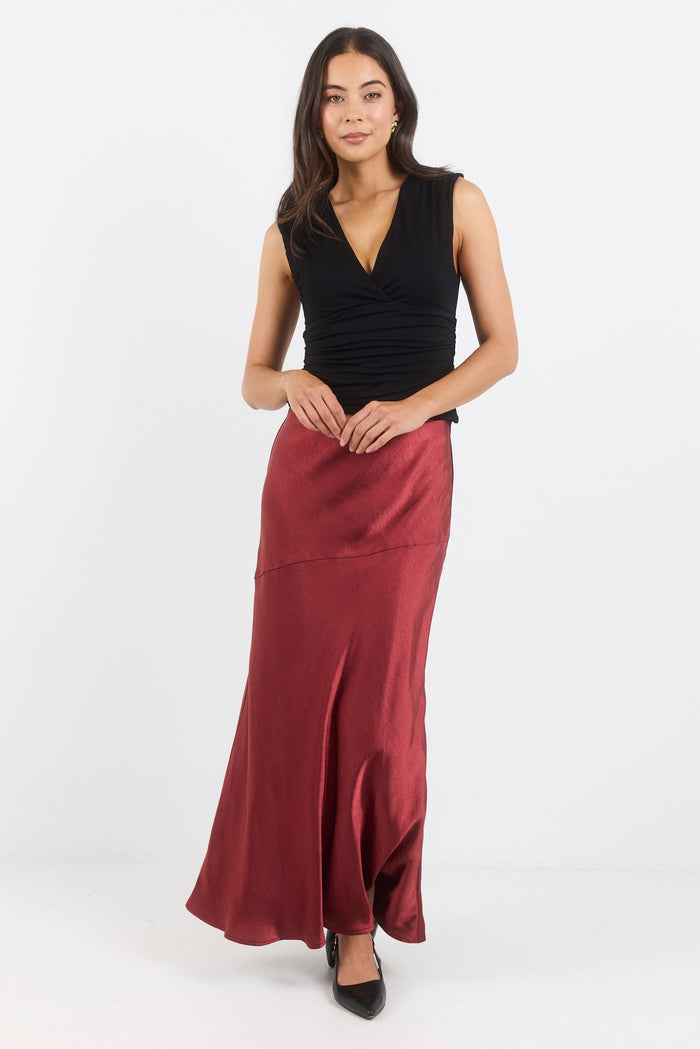 Woman wearing a black top and red skirt on a white background