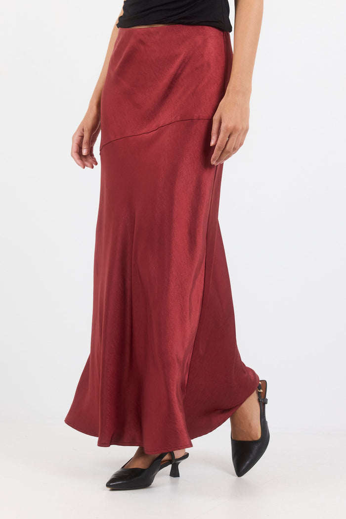Maroon skirt worn by a person on a white background