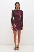 Woman wearing a burgundy dress with floral patterns on a white background