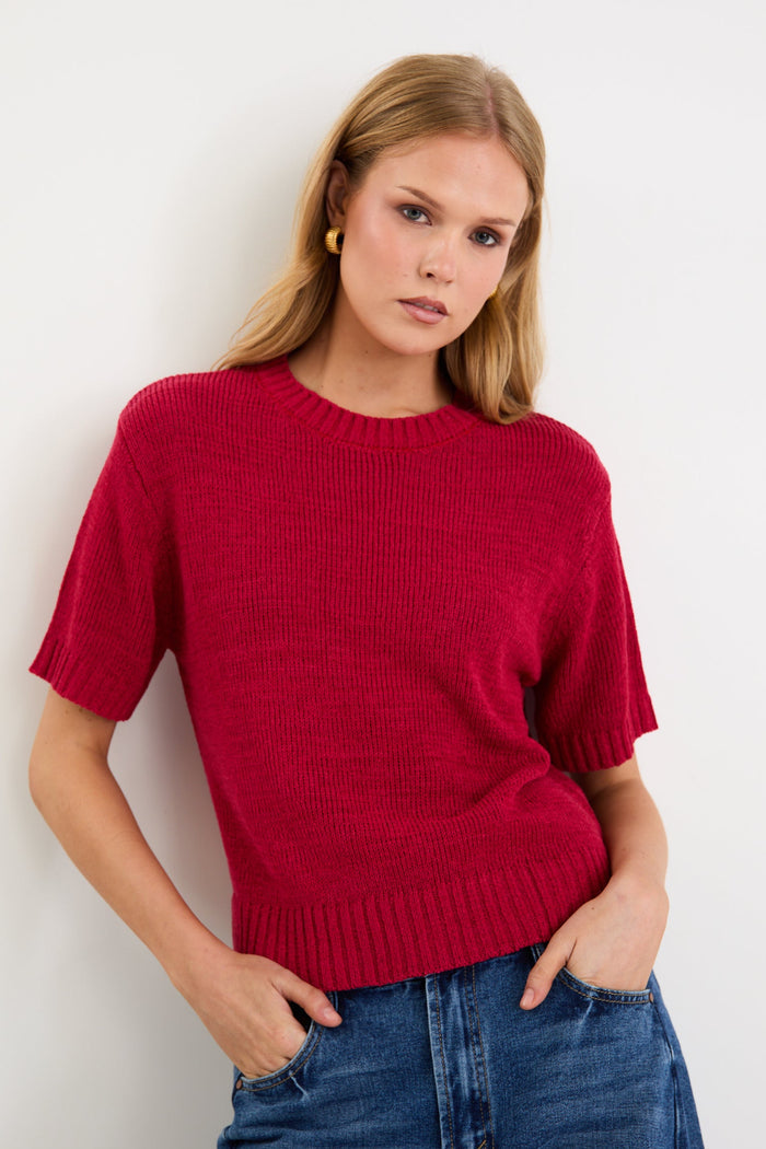 Model wearing a cherry red short sleeve knit tee with a crew neckline and side splits.