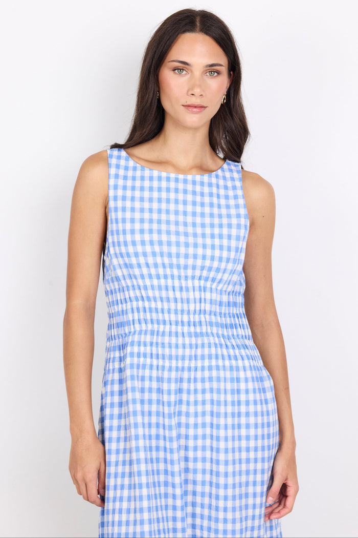 A woman modeling a sleeveless blue and white gingham dress against a plain white studio background.
col_pattern