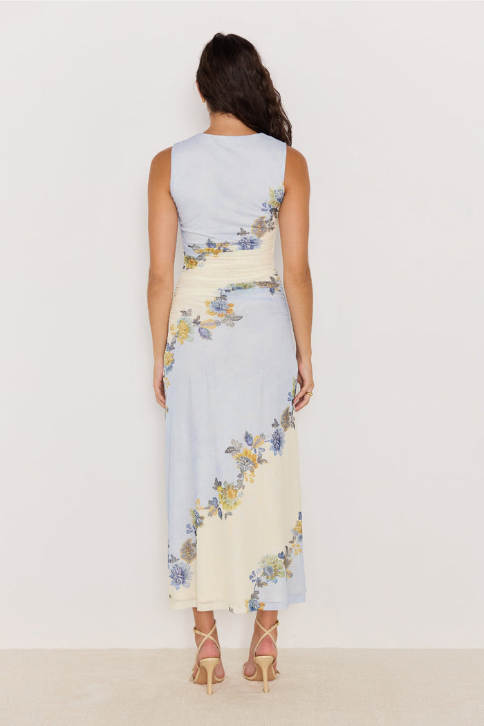 Woman wearing a sleeveless dress with floral pattern on a plain background