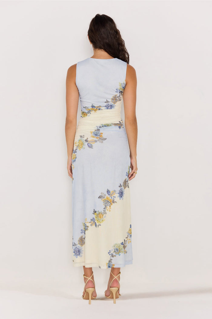 Woman wearing a sleeveless dress with floral pattern on a plain background