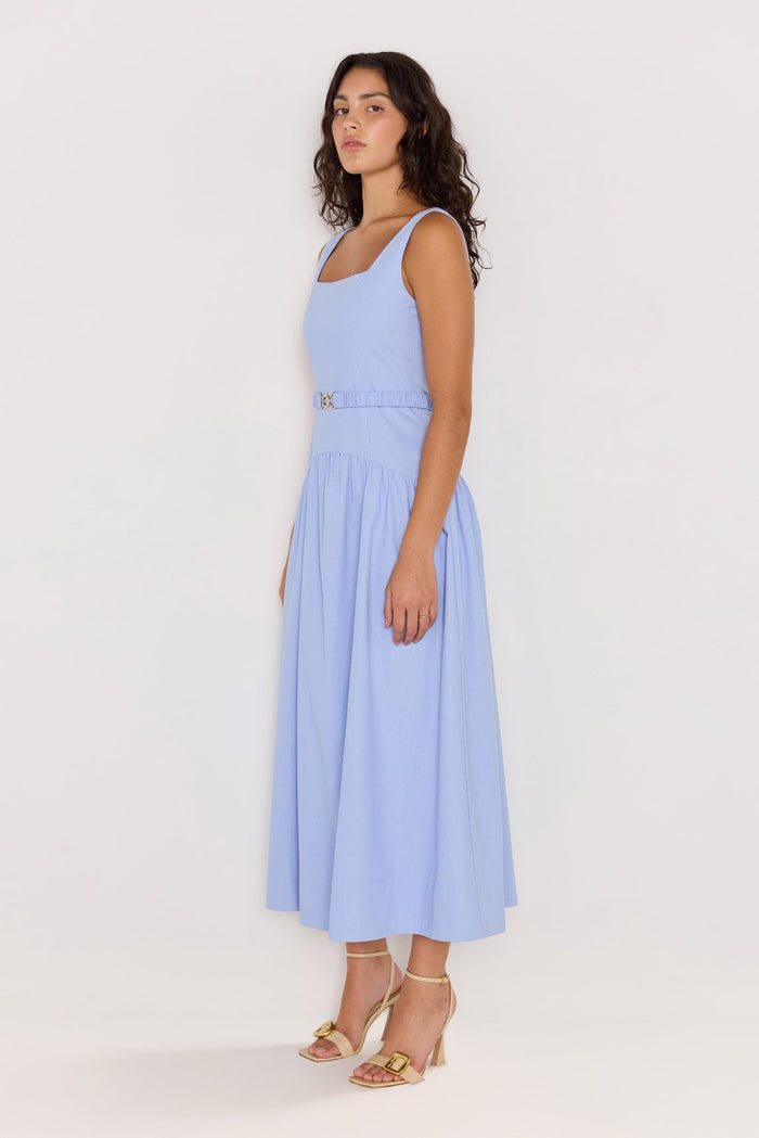 Woman wearing a light blue dress against a white background