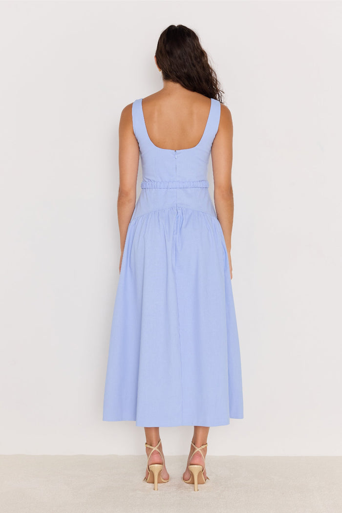 Woman wearing a light blue dress against a white background