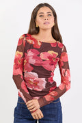 Woman wearing a floral long-sleeve top with a white background