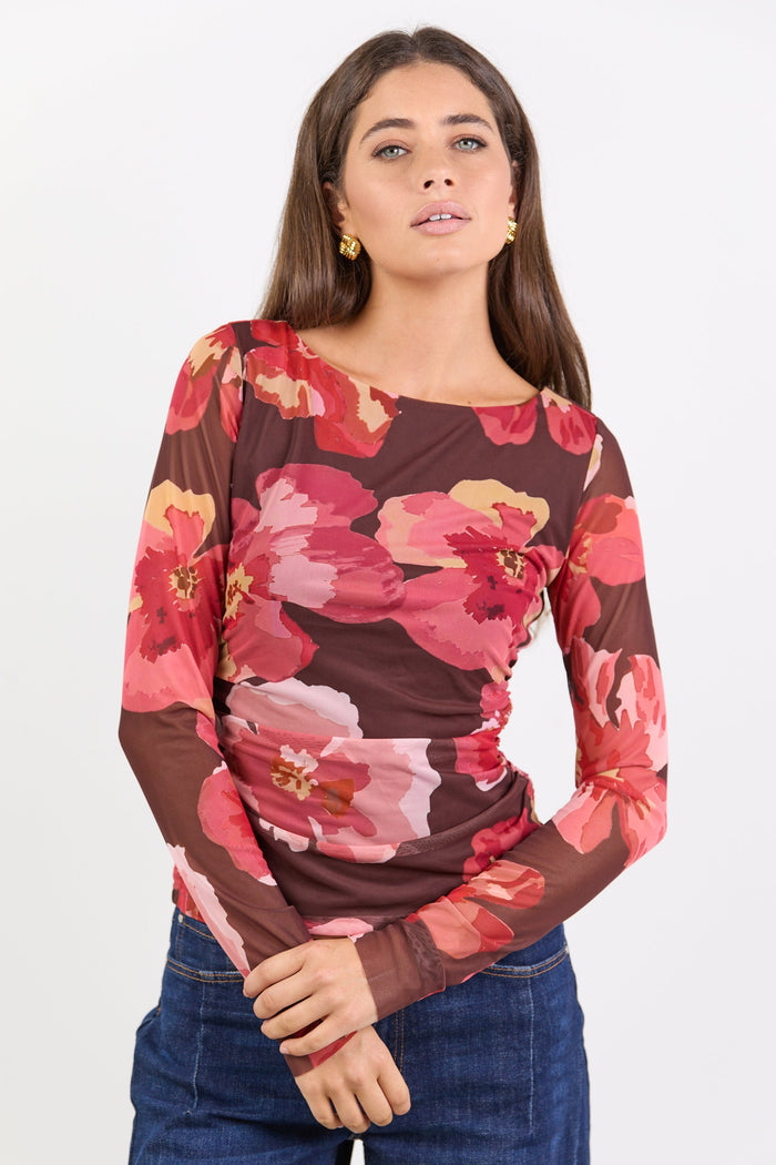 Woman wearing a floral long-sleeve top with a white background