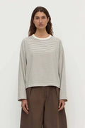Person wearing a striped shirt and brown pants against a white background
