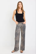 Woman wearing a black tank top and leopard print pants on a white background