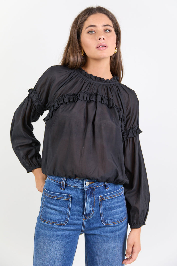 Women wearing black blouse with blue jeans.